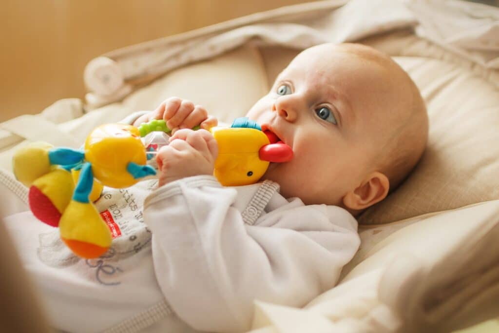 bébé avec un jouet à la bouche