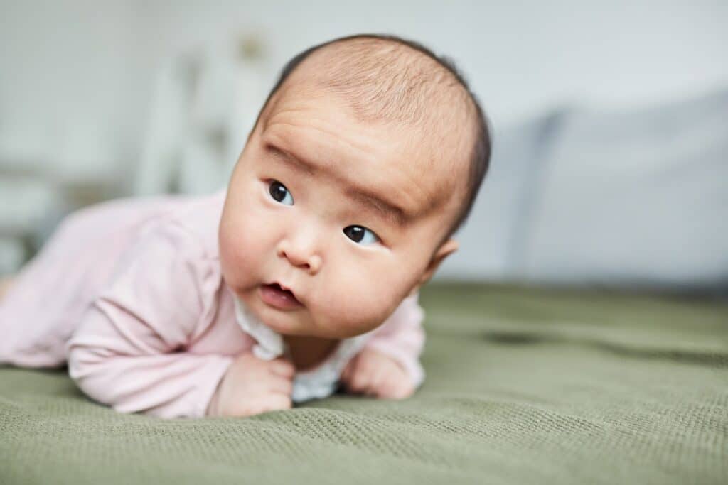 bébé sur le ventre essaye de se retourner