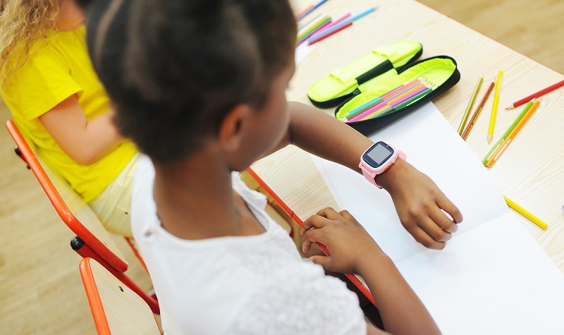 fillette noire avec une montre au poignet