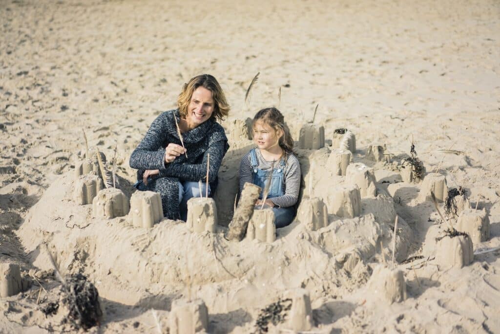 mère et fille construisent un château de sable