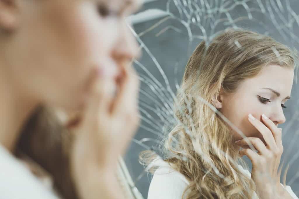 femme devant un miroir brisé