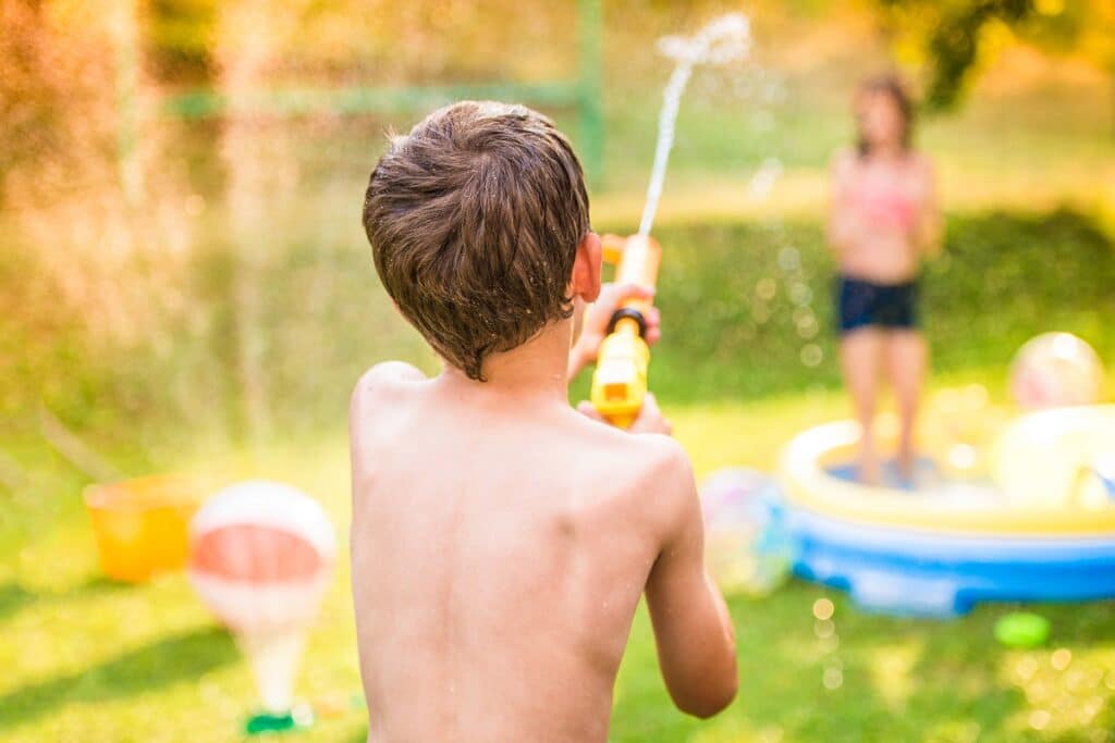 enfant joue pistolet à eau