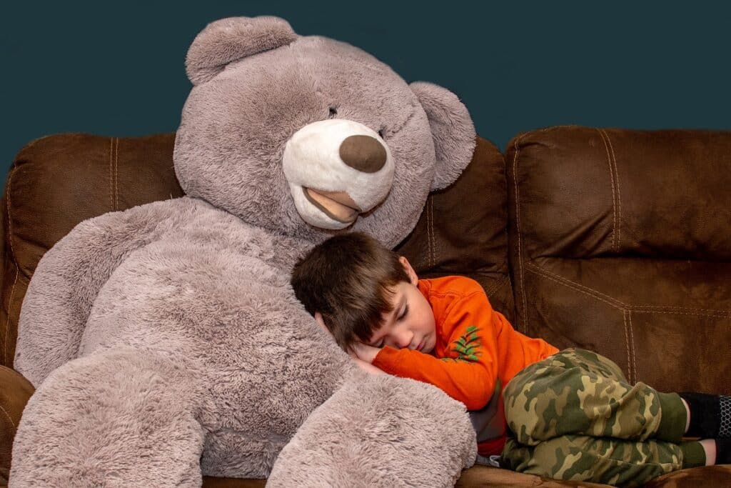 garçon dort avec ours peluche géant