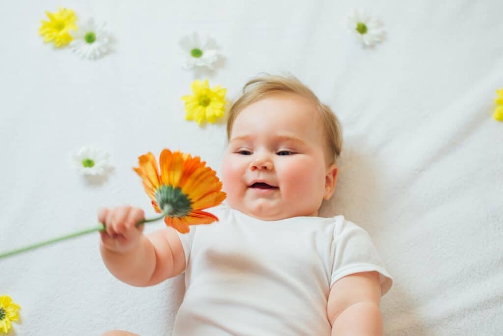 bébé avec une fleur dans la main