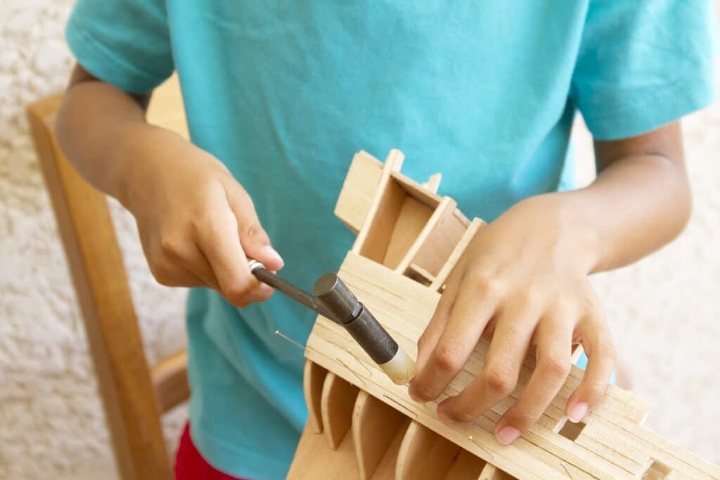 enfant construit maquette bateau