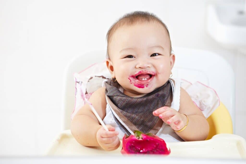 bébé mange pot de comporte de fruit