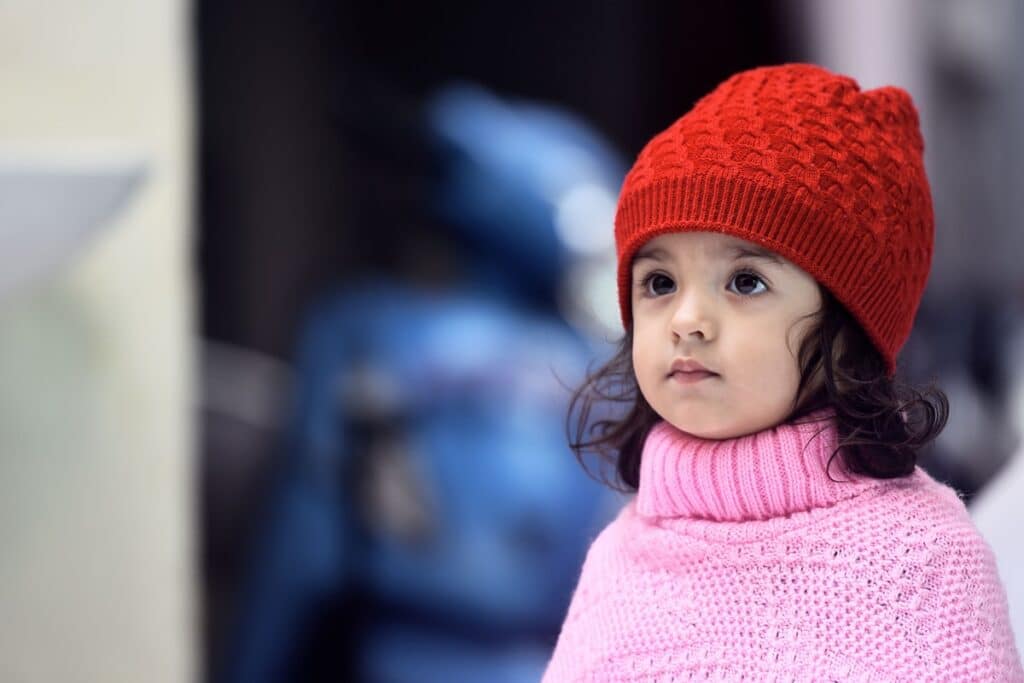enfant portant un poncho en laine rose