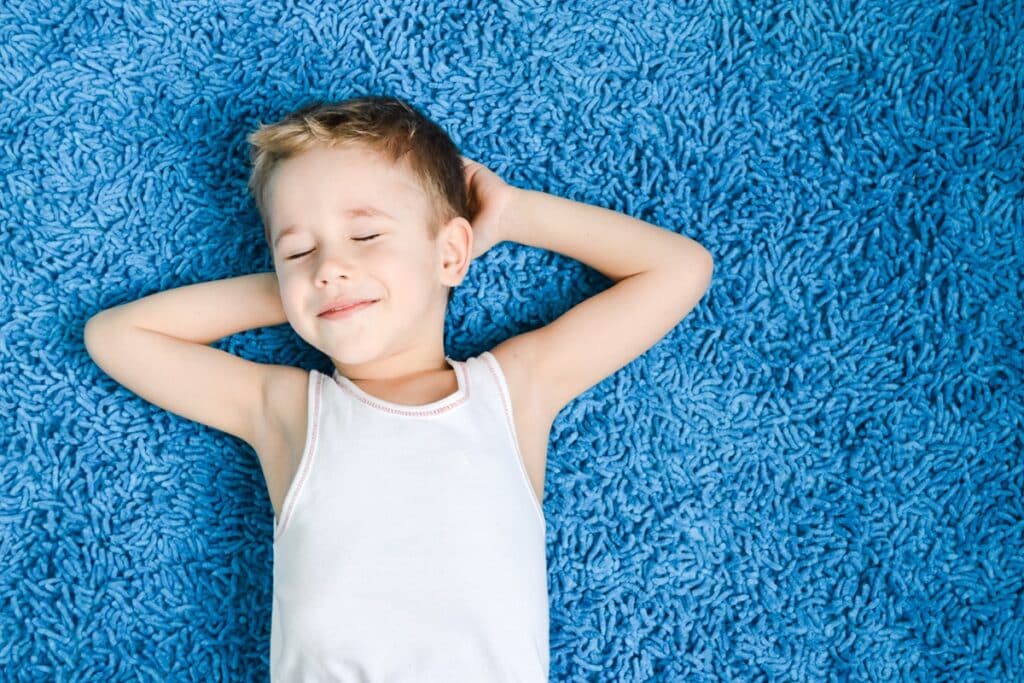 enfant sur un tapis de sol bleu