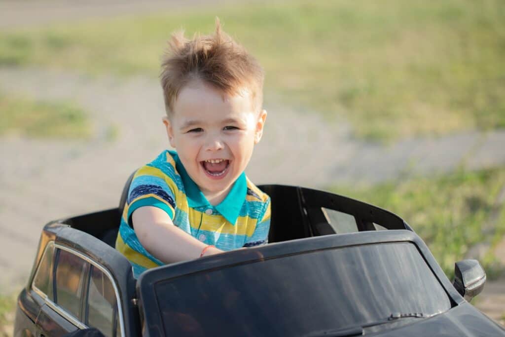 garçon conduit une voiture électrique pour enfant
