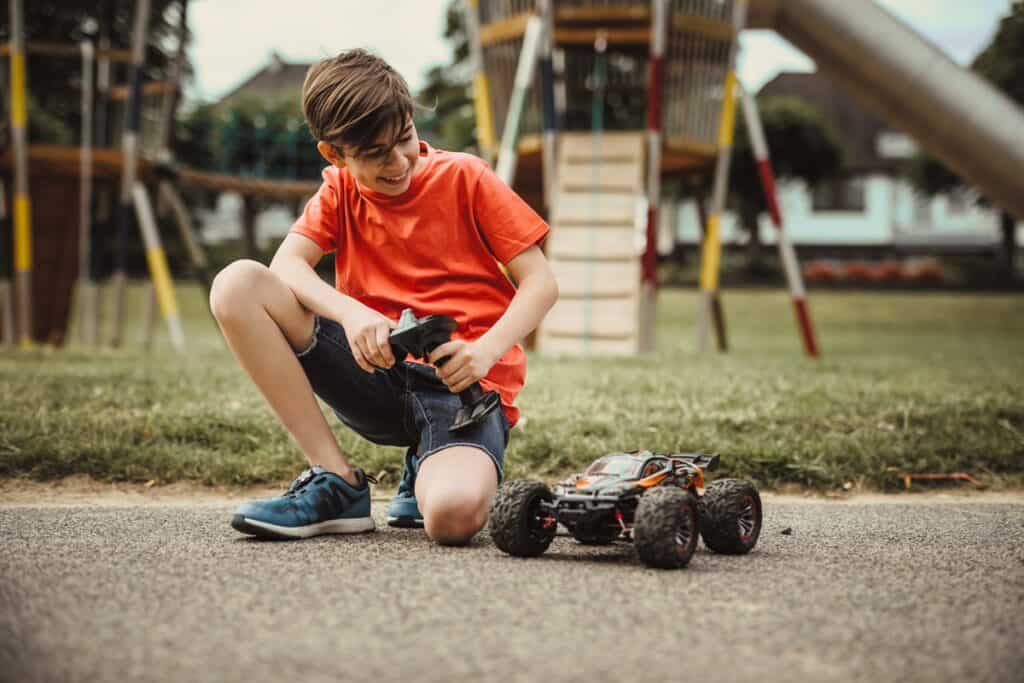 adolescent jouant avec une voiture télécommandée