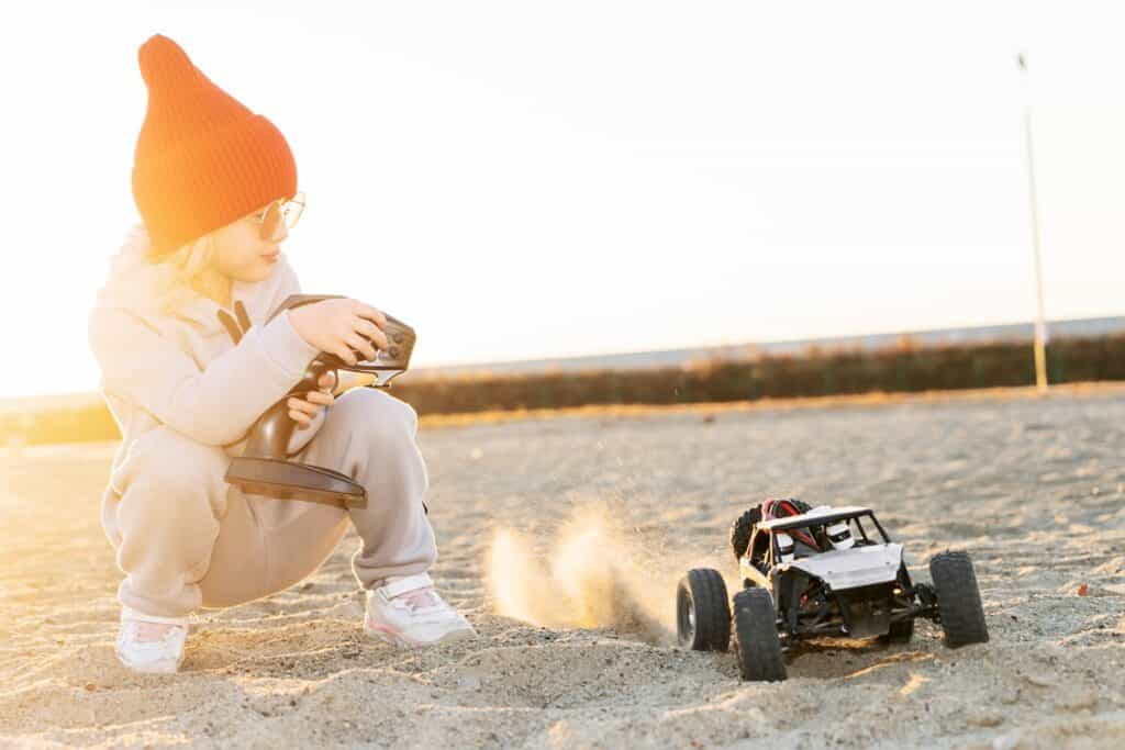 jeune fille jouant avec une voiture télécommandée tout terrain
