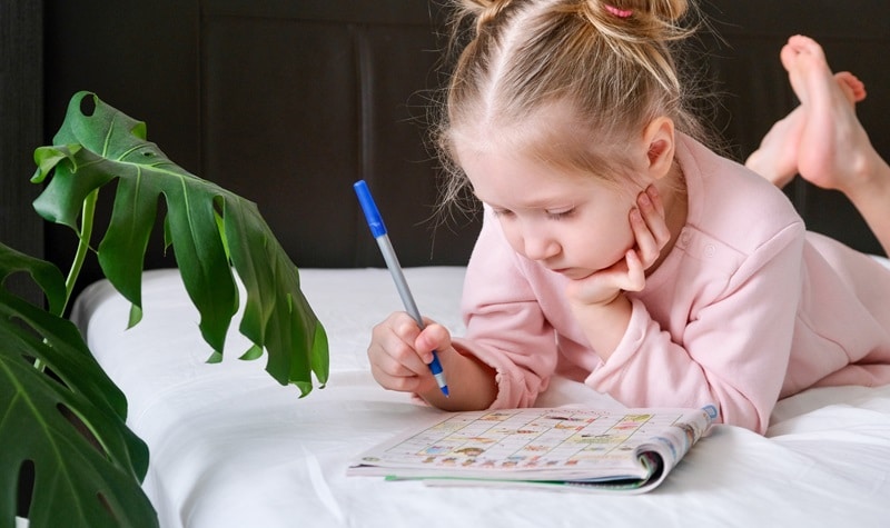 enfant qui fait des mots croisés