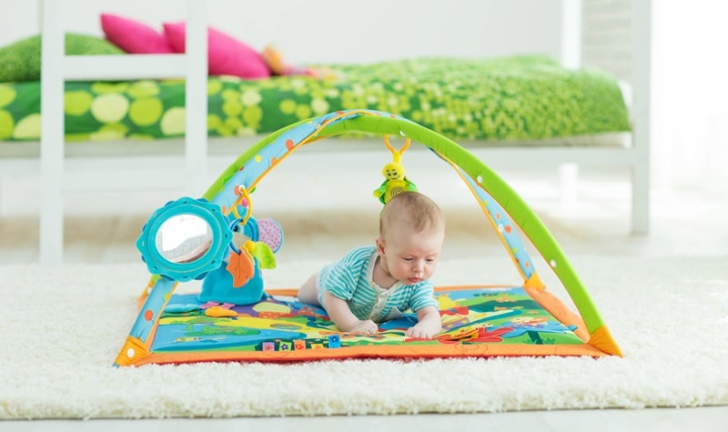 bébé joutant sur un tapis de jeu
