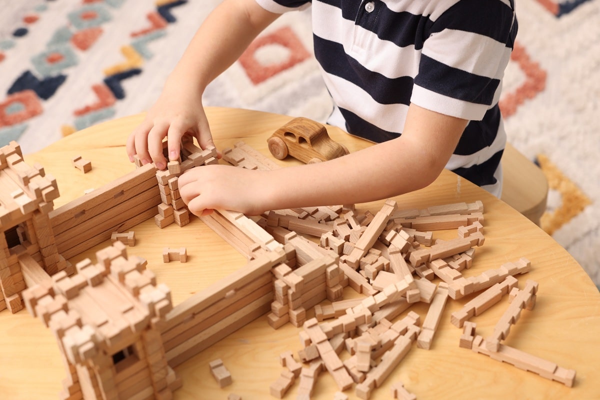 enfant jouant avec un jeu de construction en bois