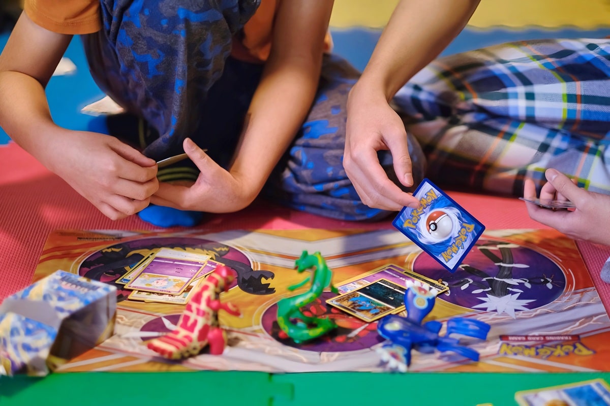 enfants jouant une partie de cartes Pokémon