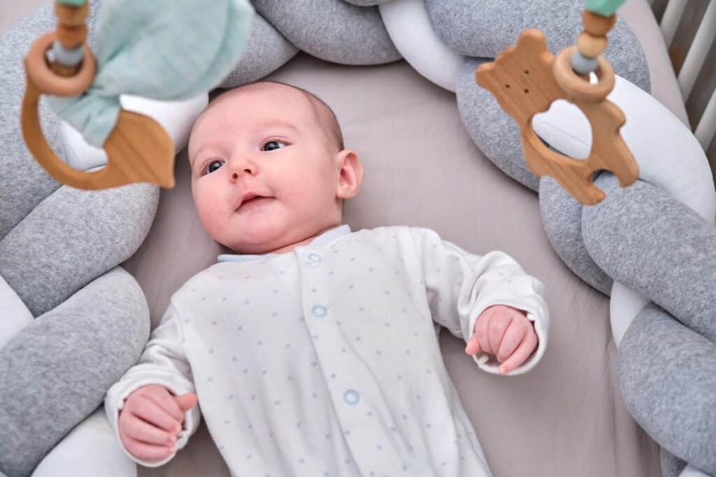 bébé dans son lit entouré d'une tresse de lit