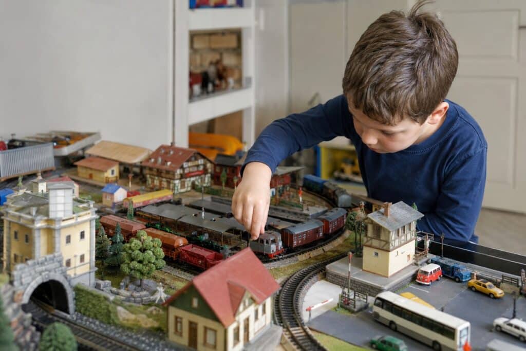 enfant jouant avec un train miniature HO