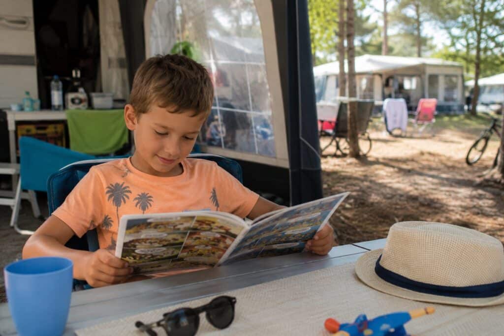 enfant lisant un magazine en vacances
